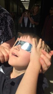 student with eclipse glasses